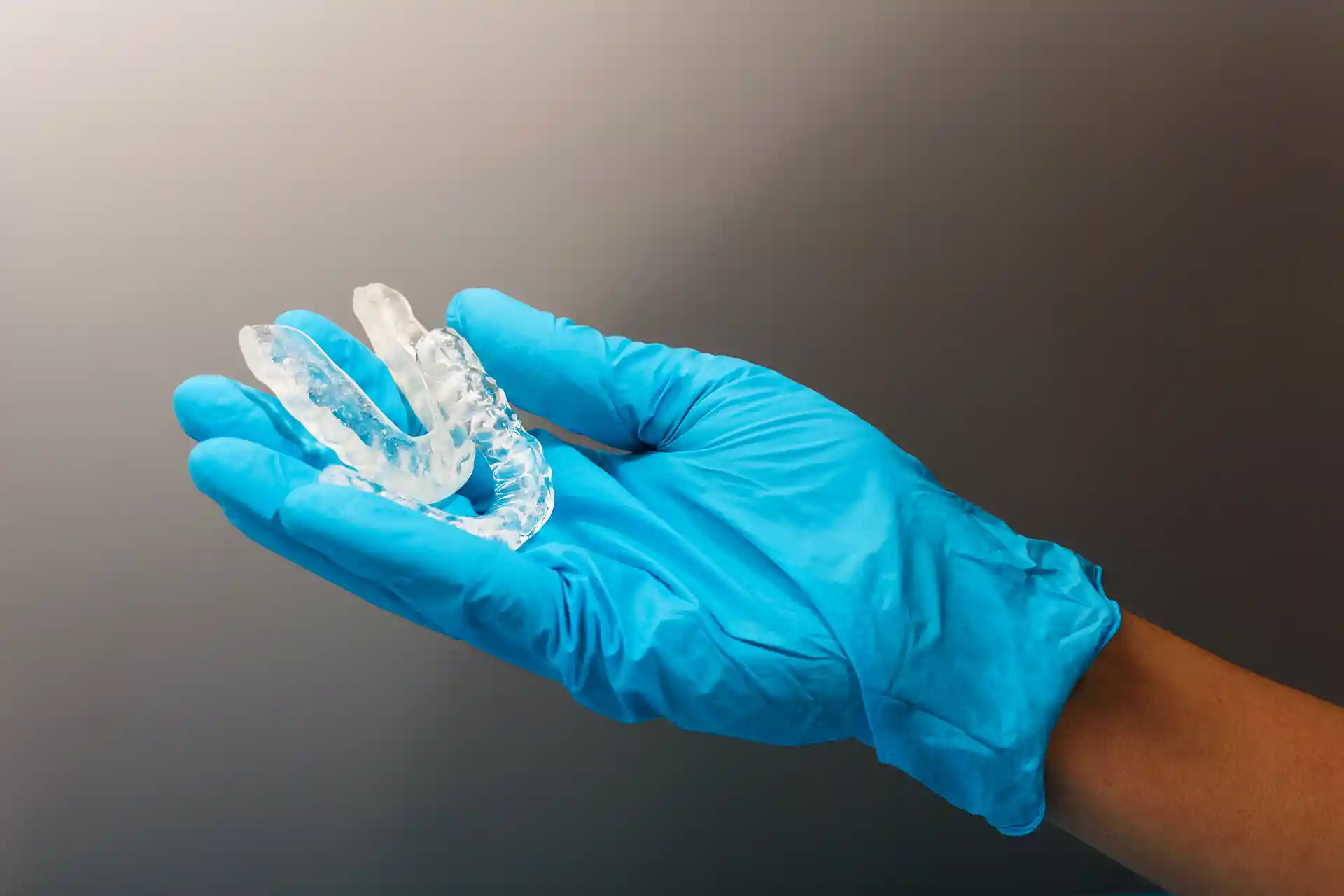 dental professional holds mouth guards