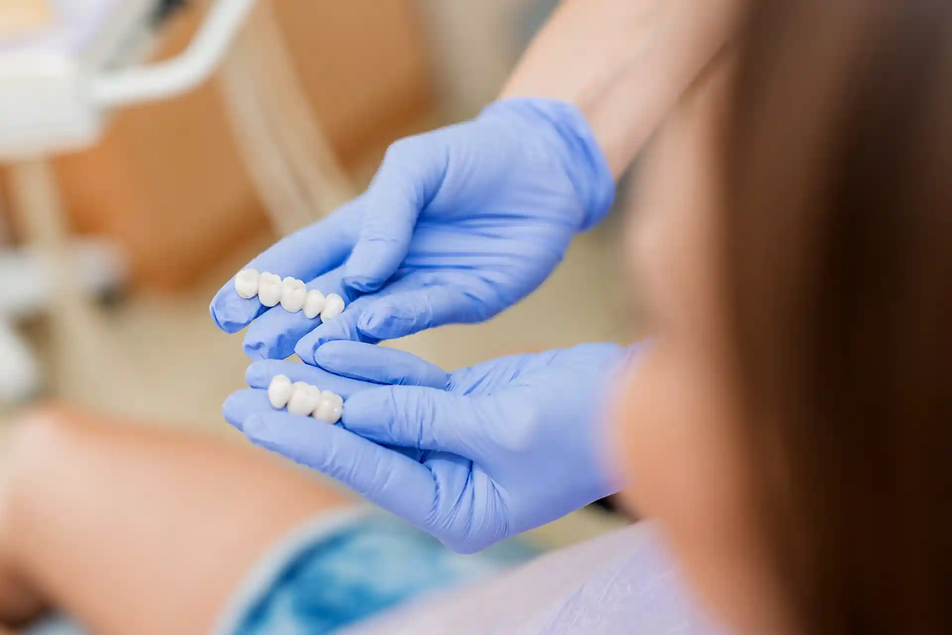 dentist hands holding dental bridge