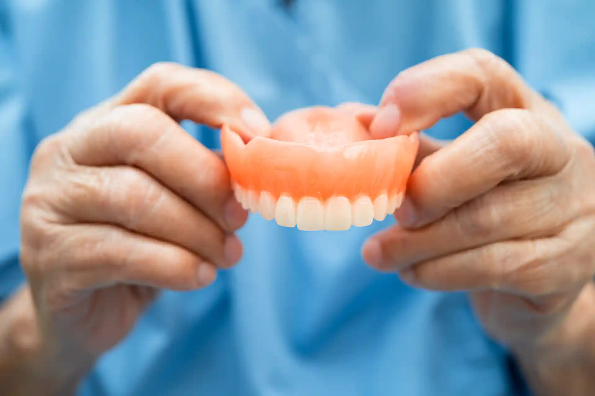 dentures being held by person