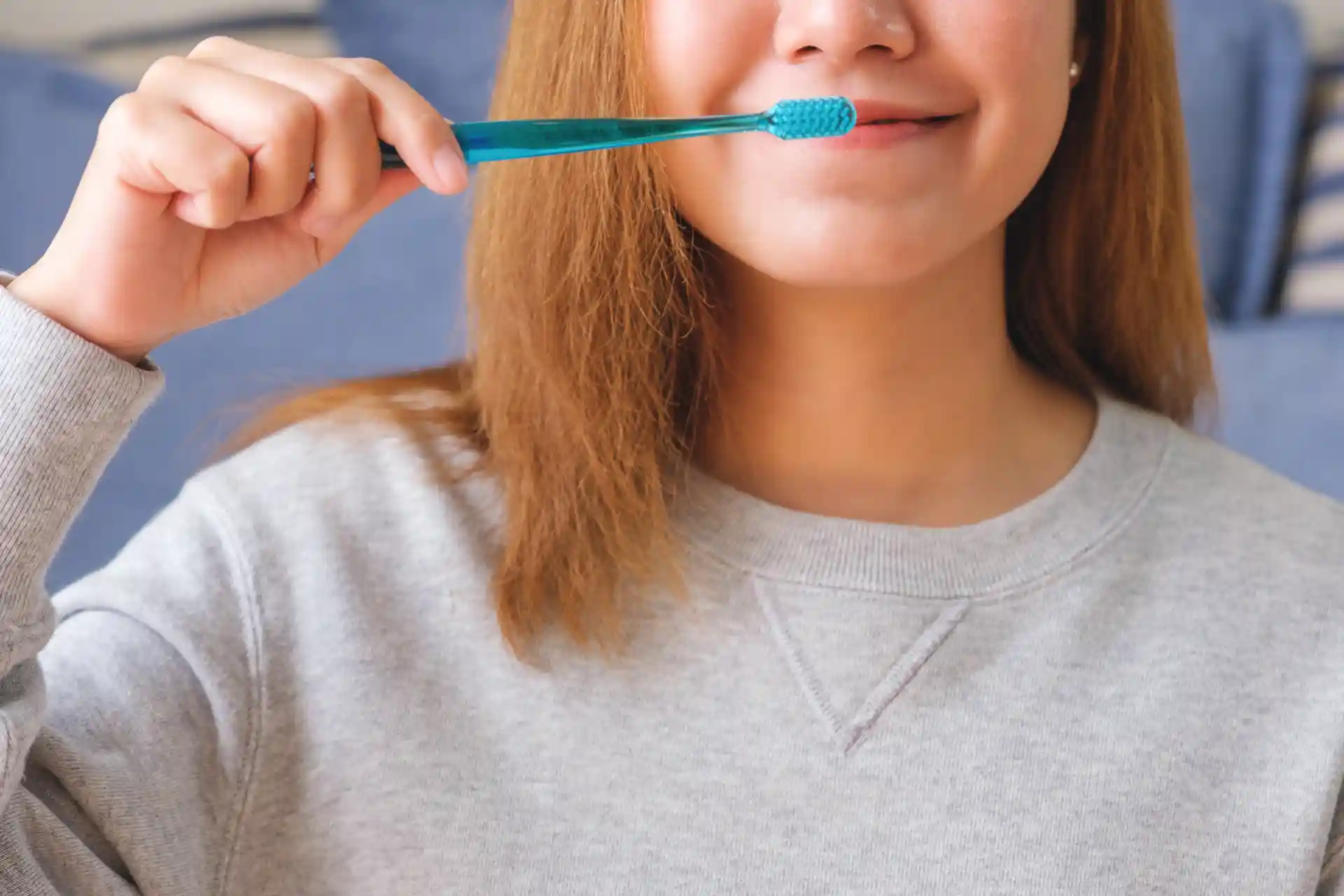 woman brushing teeth with toothbrush