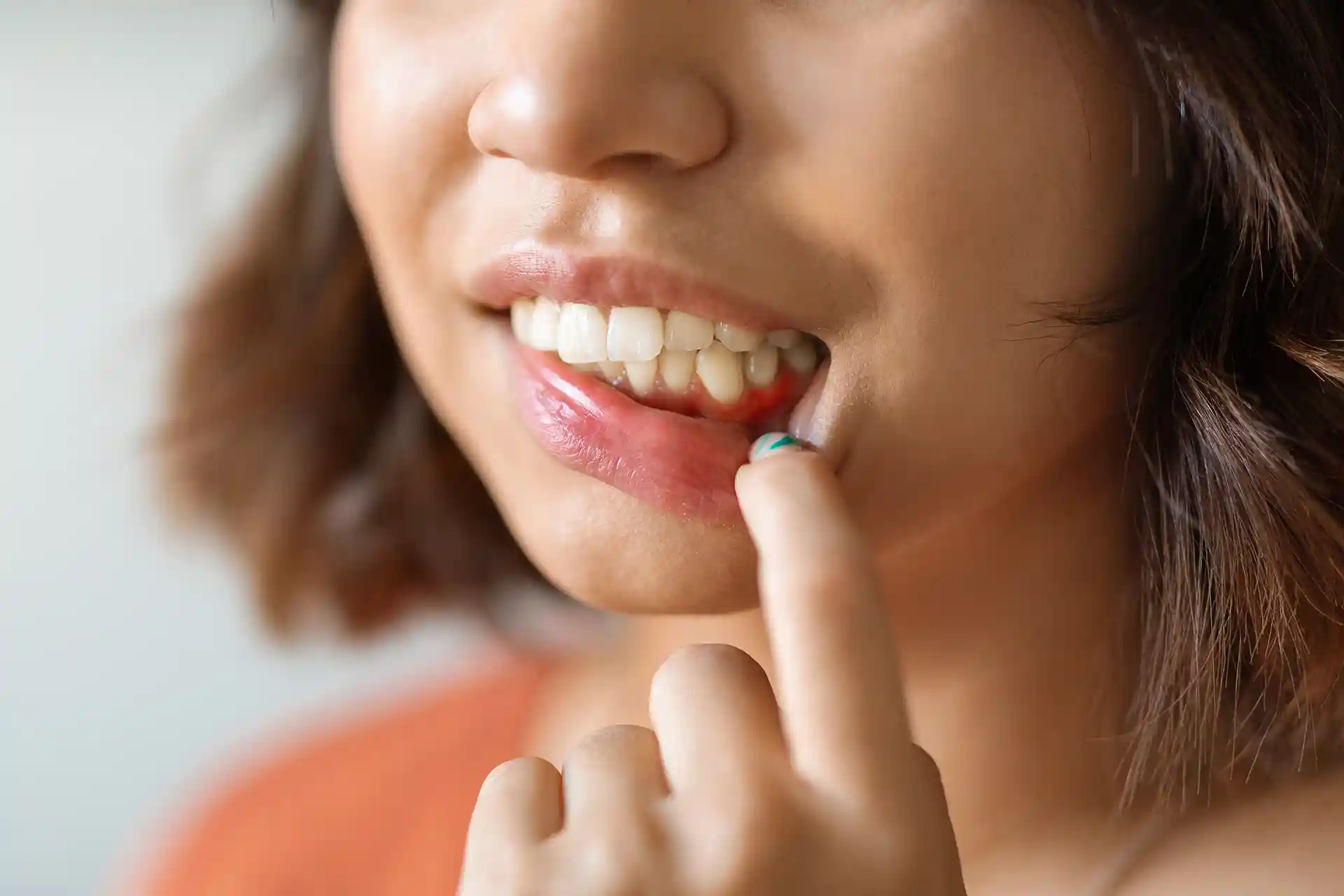 woman open mouth with finger near gums close up